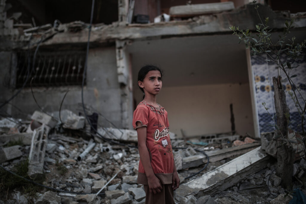 BEIT HANOUN, GAZA - MAY 29: A child stands in front of a destroyed building targeted by Israeli attacks in Beit Hanoun, Gaza on May 29, 2021. After the ceasefire deal between Israel and Hamas which was reached following 11 days of the worst fighting between the two sides in recent years, daily life in Gaza began to return to normal. (Photo by Mustafa Hassona/Anadolu Agency via Getty Images)